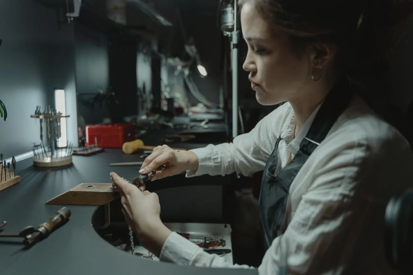 The maker at her bench, working with a rotary tool.