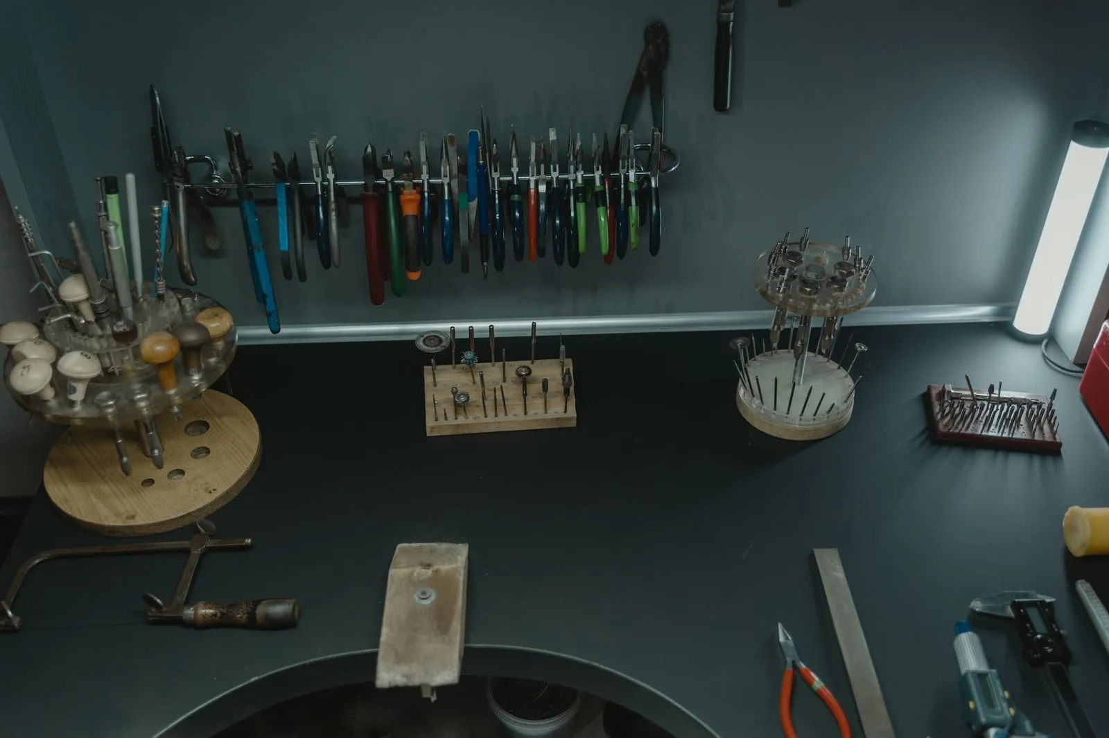 A wall of gravers, files and pliers racked above a workbench.
